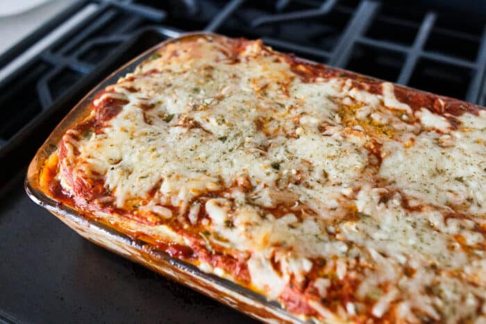 A clear casserole dish filled with eggplant lasagna with melted cheese on top