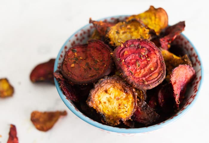 A bowl of golden and purple beets fried to become chips